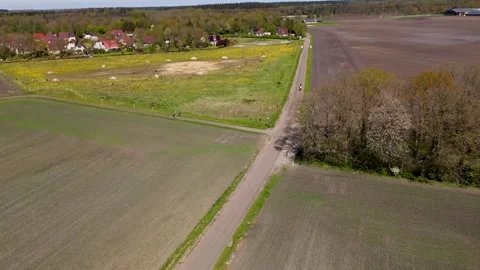 Cyclists biking on a rural path through agricultural fields and countryside 库存影片 335064265
