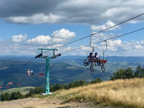 Cyclists on a cable car. Funicular to the top of Carpathians Gimba Mountain Stock Photos
