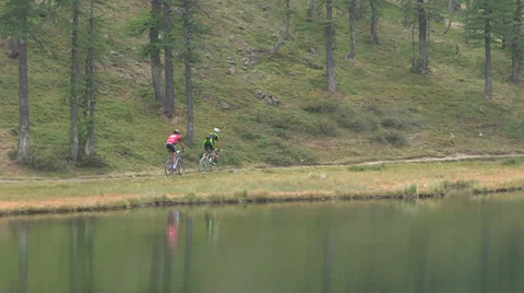 Cyclists close to small lake Stock Footage 37587441