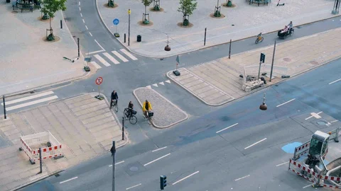 Cyclists cross road as boy in background learns to ride bike in Copenhagen Stock Footage 128093358