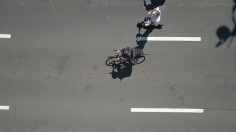 Cyclists. Cyclists ride in a column along the road. Aerial view. Stock Footage 156523920