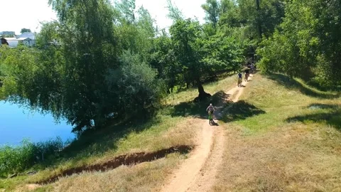 Cyclists in different clothes and protective helmets on a mountain bike Stock Footage 136024582