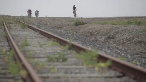 Cyclists on a dirt path ride past train tracks in Santa Cruz Video stock 91277112