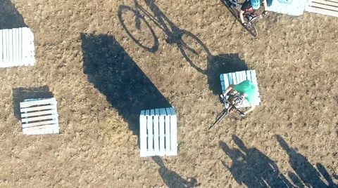 Cyclists doing jump MTB tricks in bicycle HD aerial video. Mountain bike trial Stock Footage 67861491