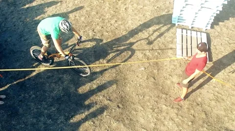 Cyclists doing tricks jumping over obstacle in MTB bicycle HD aerial video Stock Footage 67861598