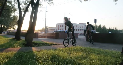 Cyclists drive along the path past the trees 스톡 동영상 103242267