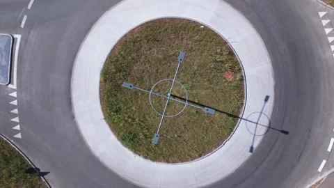 Cyclists entering and exiting empty roundabout. Aerial drone overview 스톡 동영상 316100160