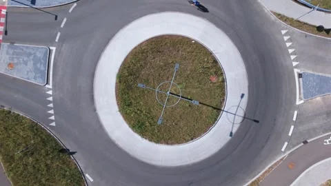 Cyclists entering and exiting empty roundabout. Aerial drone overview Video stock 316100171