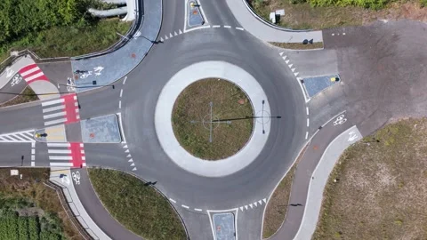 Cyclists entering and exiting empty roundabout. Aerial drone overview Video stock 316100193