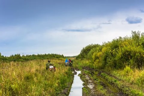 Cyclists go along the bumpy road. Stock Photos