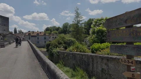 Cyclists going over Pont de pierre, Bourdeilles, Dordogne. Stock Footage 334716401