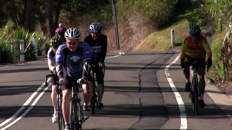 Cyclists in group ride towards camera medium telephoto Stock-Footage 54939104