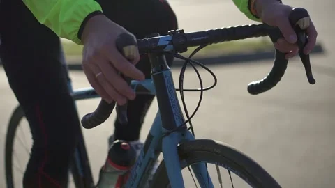 The cyclist's hands hold the steering wheel, his feet turn the pedals Stock Footage 134647358
