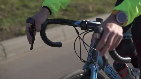 The cyclist's hands hold the steering wheel, his feet turn the pedals Stock Footage 134730682