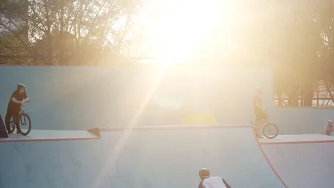 Cyclists one after another jumping on a springboard in a skate park Video stock 103245094