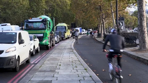 Cyclists pass by traffic jam Stock Footage 118400787