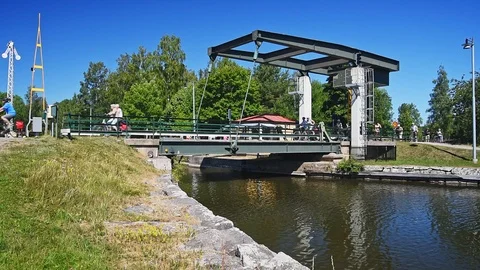 Cyclists passing canal over bridge Stock Footage 96153752