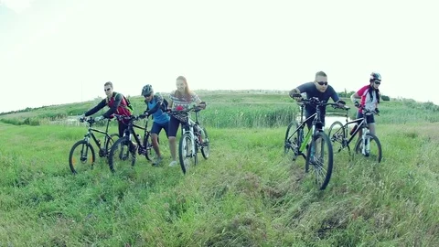 Cyclists pushing bikes up a hill Stock Footage 76593890