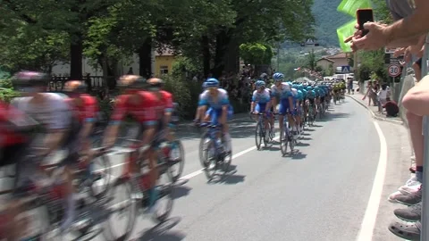 Cyclists racing through town Tolmin at tour of slovenia, fans cheering by Stock Footage 255197535