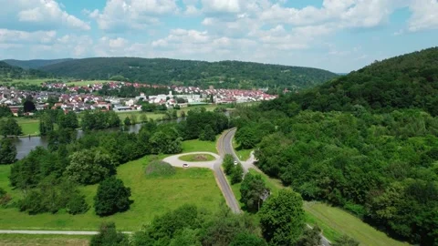 Cyclists ride the bike path next to the road leading to the city Stock Footage 155598622