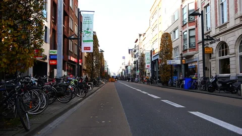 Cyclists ride down the street in front of the bus Stock Footage 93617003