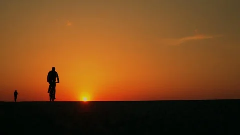 Cyclists ride in the sunset. slow motion Stock Footage 89381607