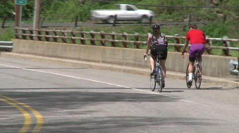 Cyclists riding alongside road (8 of 9) Stock Footage 32031349