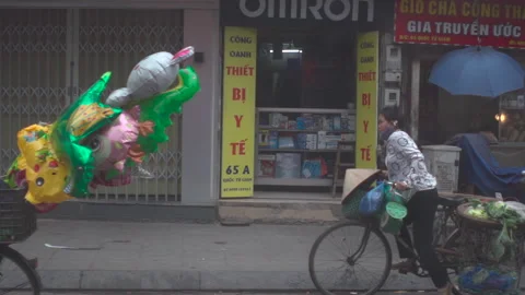 Cyclists riding alongside some shops in the morning 库存影片 272284605