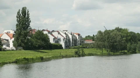 Cyclists riding down a promenade next to a river with clouds in the background Stock-Footage 131275959