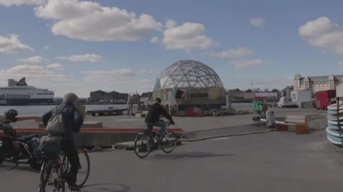 Cyclists Riding Past Geodesic Dome Structure on City Harbor Promenade Stock Footage 340960130