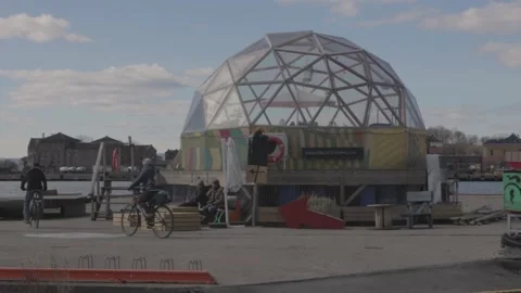 Cyclists Riding Past Geodesic Dome at Waterfront Promenade in Oslo Stock Footage 340960243