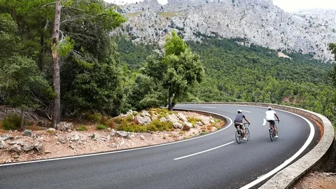 Cyclists riding up the Puig Major peak in Majorca, Spain Stock Footage 78640885