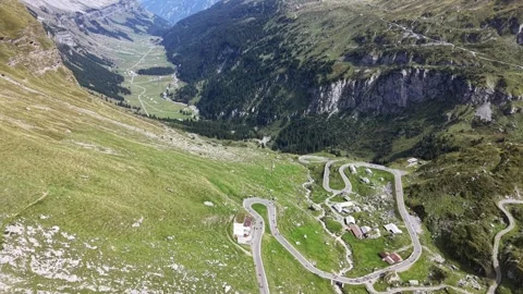 Cyclists Riding Through Layered Alpine Mountain Terrain Stock Footage 345495943