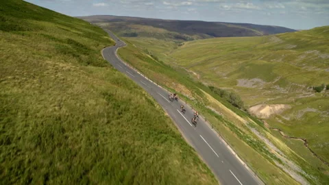 Cyclists riding on winding mountain road aerial view Stock Footage 336804498