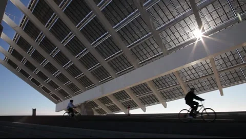 Cyclists running under the large solar panel. Barcelona. Stock Footage 2169662