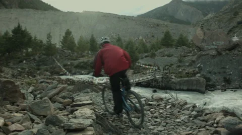 Cyclists rush aside a raging river Stock Footage 64306295