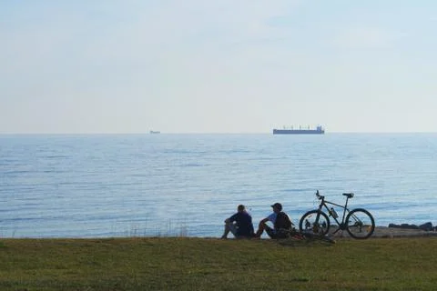 Cyclists sit on the background of the sea Stock Photos