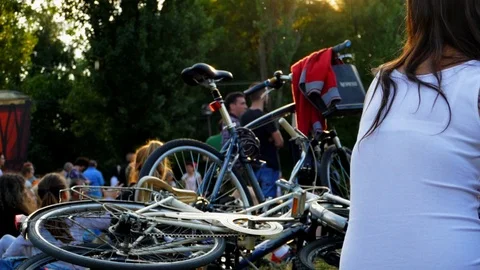 Cyclists sit in the park during a picnic in the light of the setting sun Stock Footage 90348396