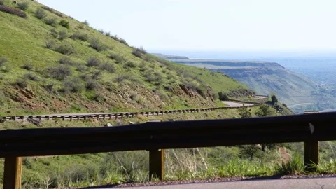 Cyclists Speed Through Frame and Continue Down Mountain Road Stock Footage 168760799