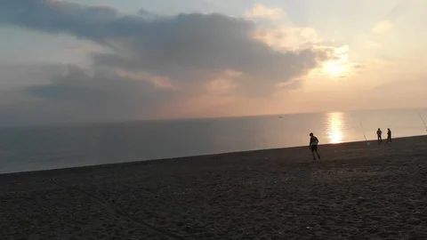 Cyclists spending time in a beautiful beach with the sunrise Stock Footage 98689581