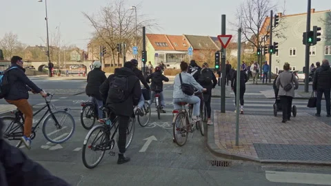 Cyclists stopped at traffic lights at an intersection in Odense Stock Footage 197493611