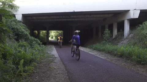 Cyclists under bridge pcn path green corridor singapore Stock Footage 151459324