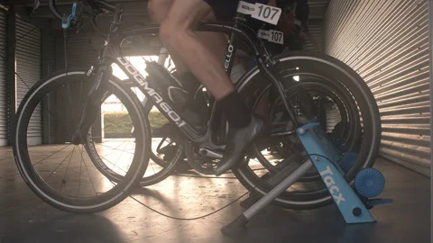 Cyclists warming up on wind trainers before a race Stock Footage 247239511