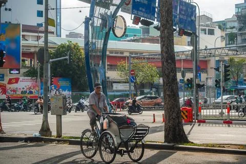 Cyclo Driver Navigating a Busy Intersection in Hanoi Foto stock