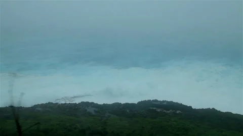 Cyclone driven waves crash against rocky shoreline Stock Footage 50302417
