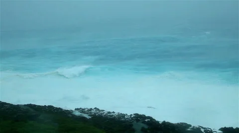 Cyclone driven waves crash against rocky shoreline Stock Footage 50302833