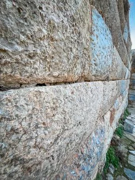 Cyclopean Stones Stack into Towering Ancient Wall from Mossy Base Фото