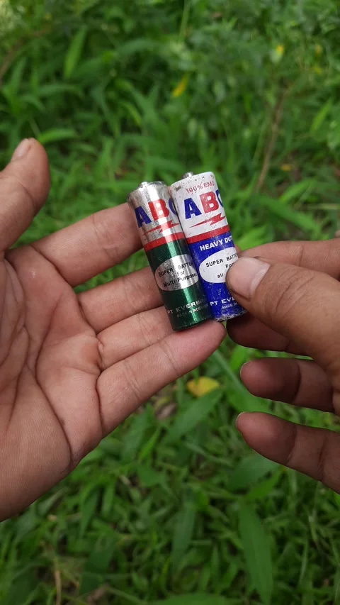 Cylindrical battery pair clip, green and blue paper wrapped cells, hand-hel.. Stock Footage 345114144