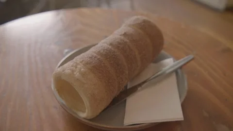 Cylindrical Sugar-Dusted Pastry Served on Plate in Sydney Cafe Interior Stock Footage 345660395