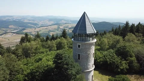 A cylindrical tower standing amidst a lush, dense forest in Loire, France Stock Footage 301384052